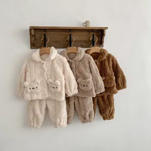 Détail d'un pyjama en peluche pour bébé avec poche ours et texture polaire douce
