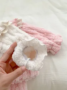 Detail of pink fleece baby shirt showing elastic cuffs and delicate lace ruffles