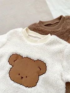 Close-up of soft plush teddy fleece baby rompers with cute brown bear patches