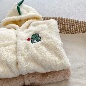 Detail of soft fleece baby romper with dinosaur embroidery and cozy textured fabric