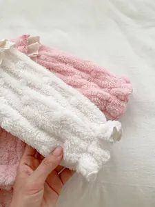 Close-up of thick plush baby thermal set with delicate lace trim and ruffle details