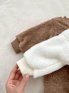 Close-up of soft sherpa fleece baby rompers showing textured fabric and ribbed cuffs