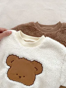 Close-up of fluffy polar fleece fabric with cute bear embroidery on toddler sweatshirt