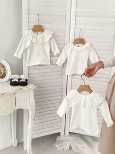 White cotton baby girl long sleeve tops with delicate lace ruffle collars displayed on white screen