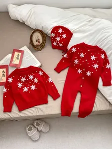 Detail of red baby knit set featuring 3D white flower embroidery and pearl accents
