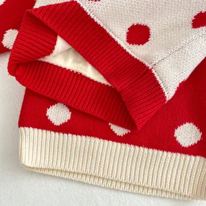 Gros plan d'un pull en maille à pois rouges et blancs avec une doublure en polaire douce