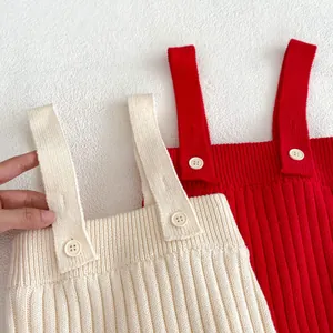 Détail de la maille côtelée et des boutons de fixation sur l'ensemble pour bébé