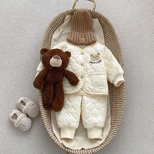 Detail of baby quilted winter set featuring a bear embroidery and HAPPY DAY text