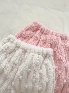 Close-up of thick plush baby loungewear showing soft white and pink polar fleece texture