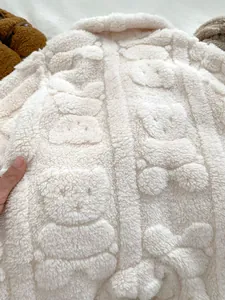 Detailansicht von warmem Sherpa-Fleece mit geprägtem Bärenmuster für Baby-Einteiler