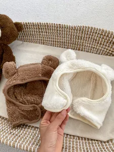 Detail of plush baby bear hats in brown and cream with cute ears and soft texture