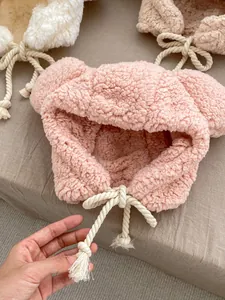 Detail of plush bear ear hat showing soft fleece texture and cotton drawstring ties