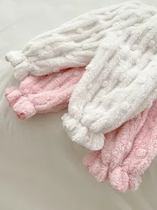 Detailed view of winter baby thick plush trousers with ruffled cuffs in white and pink