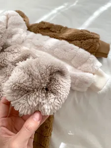 Nahaufnahme von weichem Sherpa-Fleece und Rippbündchen an gemütlichen Baby-Einteilern