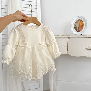 Detail of baby girl romper dress with waffle cotton texture and intricate lace embroidery