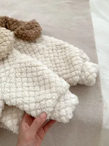 Close-up of thick white waffle fleece fabric with soft texture and 3D plush ears