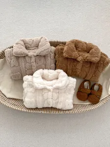Flachbild von weichen Baby-Stramplern aus Fleece und Plüschschuhen im Korb