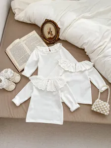 Detail of baby girl white cotton blouses with ruffled lace collars and embroidery