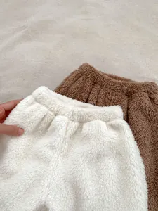 Detail of plush sherpa fleece pants with elastic waistband in cream and brown