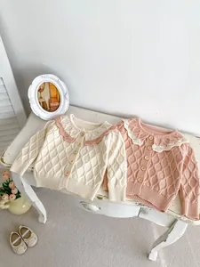 Détail de l'ensemble cardigan en maille pour bébé avec motif losange et col à volants