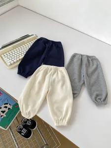 Detail of three waffle knit kids jogger pants in navy, cream and grey colors