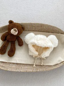 Detail of plush baby bear hat with warm fleece lining and cream braided drawstrings