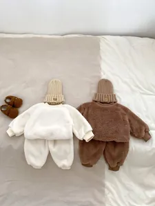 Detailed flat lay of warm polar fleece baby sets in cream and brown with cute bear hats