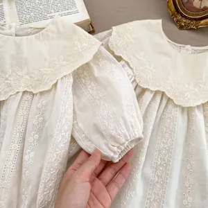 Detail of baby blouse featuring vintage floral embroidery and wide lace Peter Pan collar