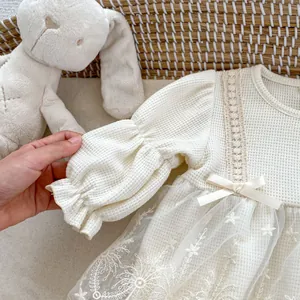 Detail of baby dress waffle fabric with lace ribbon bow and starry mesh embroidery