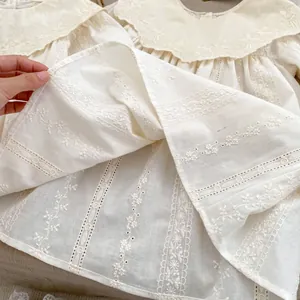 Detail of floral embroidery and hollow lace on the white cotton baby dress collar