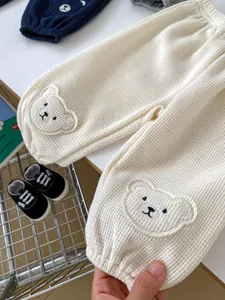 Detail of baby waffle knit joggers with 3D bear embroidery on knees and elastic waist