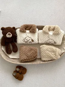 Detail of plush baby winter set with dog embroidery and soft quilted texture