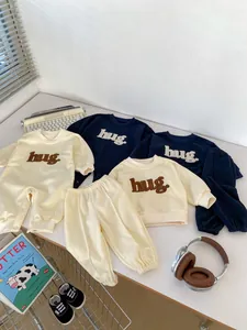 Detail of soft cotton baby romper with hug letter embroidery and ribbed sleeve cuffs
