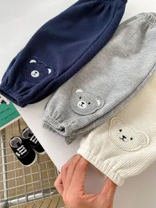 Detailed waffle texture on baby joggers featuring cute bear patches in three soft colors