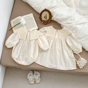 Detailed embroidery and lace collar on beige baby bodysuit and dress set