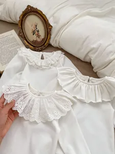 Detailed comparison of three lace collar designs on white cotton baby shirts