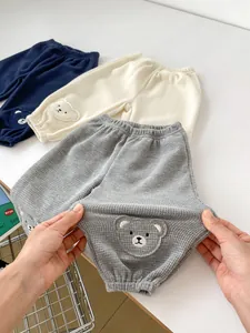 Elastic waffle knit infant pants with cute bear embroidery and stretchy fabric detail