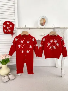 Detail of red baby knit romper with handmade floral embroidery and matching accessories