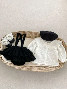 Flat lay di outfit vintage per neonata con camicia in pizzo e pantaloncini con volant