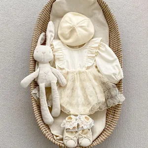 Detail of baby floral romper with lace roses, beige beret and plush bunny toy