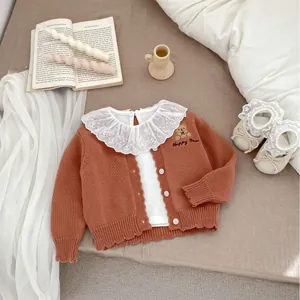 Gebreid babyvest in terracotta met berenborduursel en een verfijnde kanten kraag