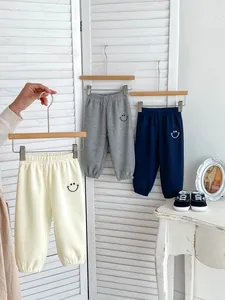 Detail of waffle fabric baby joggers with elastic waist and smiley face embroidery