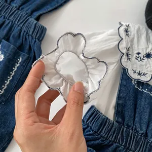 Chemisier fille blanc à manches longues brodé bleu avec salopette en jean bleue