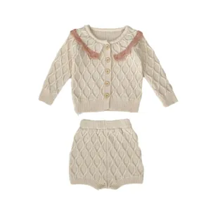 Ensemble tricoté bébé avec cardigan à losanges et short crème à col festonné rose