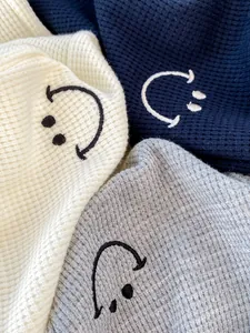 Close-up of waffle knit joggers showing smiley embroidery and soft cotton texture