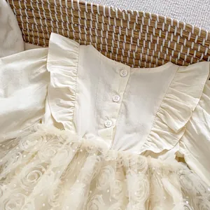 Close-up of floral mesh tulle and ruffle collar detail on beige baby princess romper