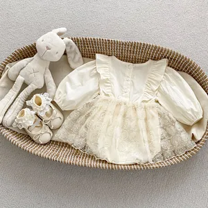 Detailed flat lay of cream ruffled baby romper with knitted lace shoes on rattan basket