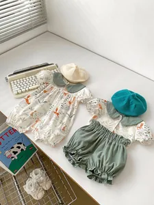 Flat lay of baby summer set with animal print romper, matching shorts and cute accessories