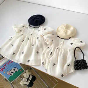 Detail van baby zomerjurk en romper met strikprint en een stijlvolle ruches kraag
