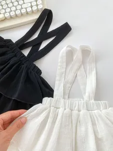 Close-up of black and white baby ruffle overall skirts in soft breathable seersucker fabric